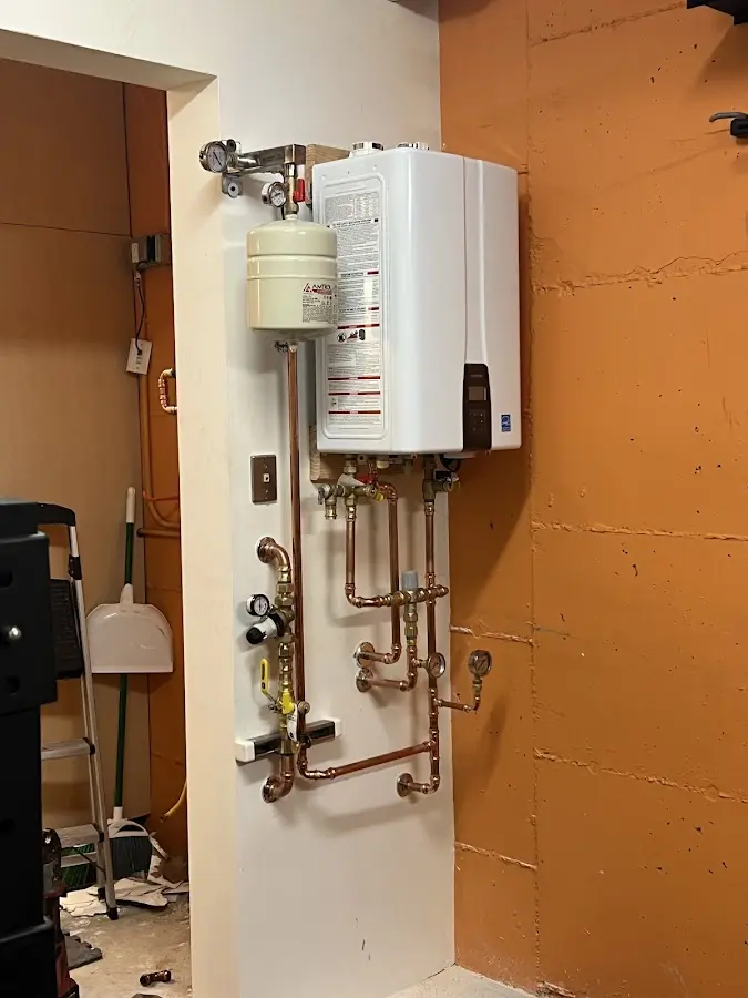 Plumbing technician inspecting water heater connections in Grand Bay